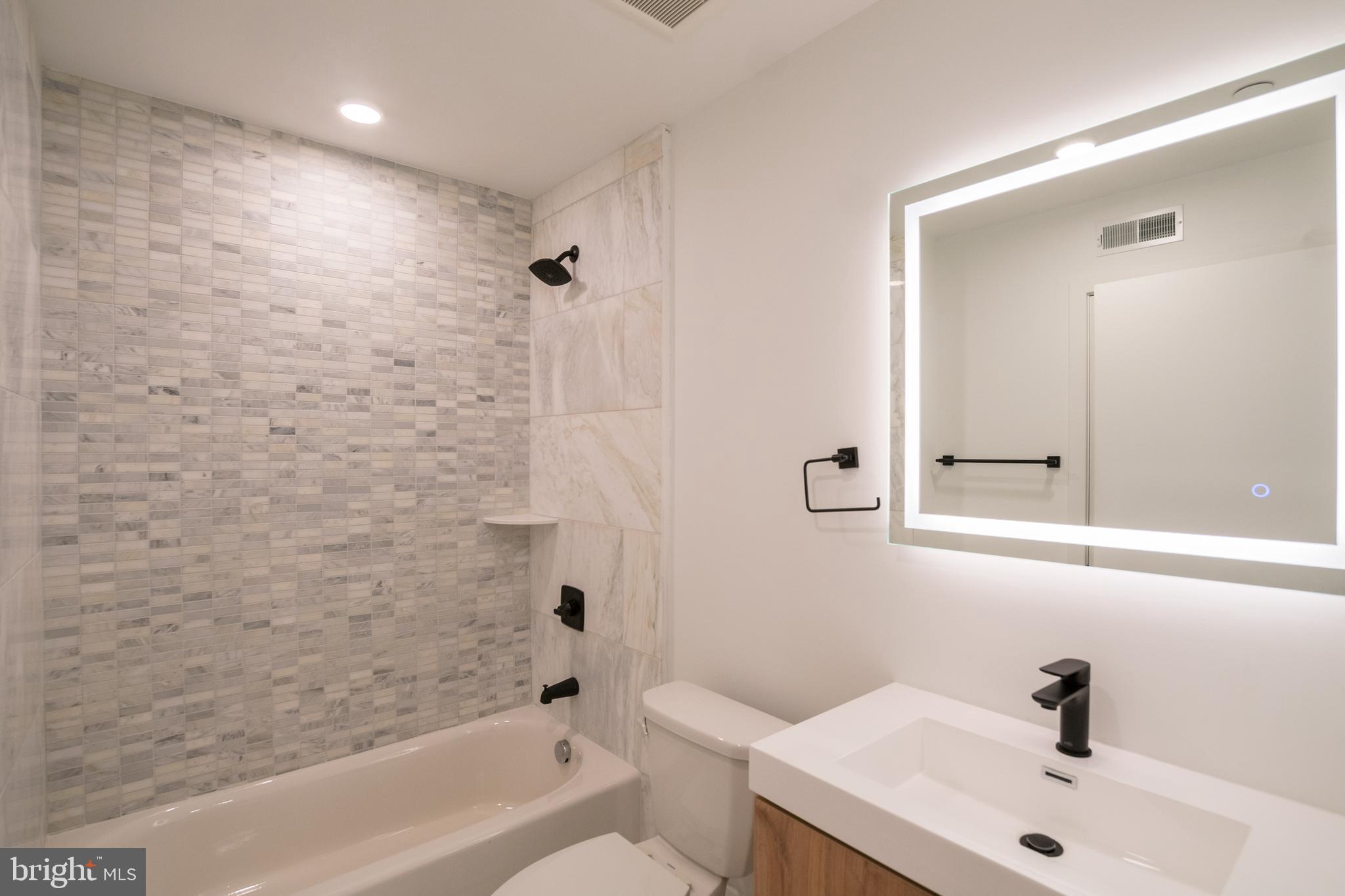 1420 Point Breeze Avenue, Unit 403 Philadelphia, PA 19146 - Photo 8 of 16 a bathroom with a sink a toilet and shower