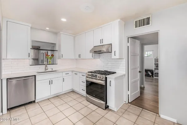 a kitchen with granite countertop white cabinets and appliances