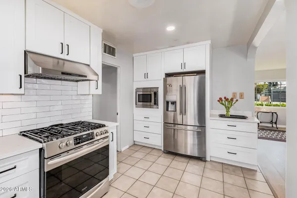 a kitchen with stainless steel appliances and cabinets