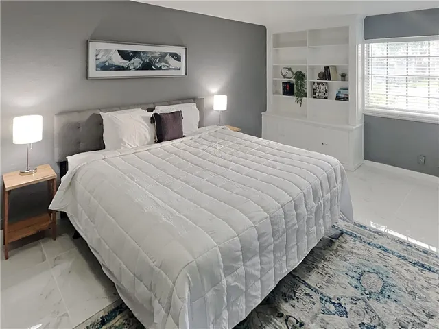 a bedroom with bed and night stand