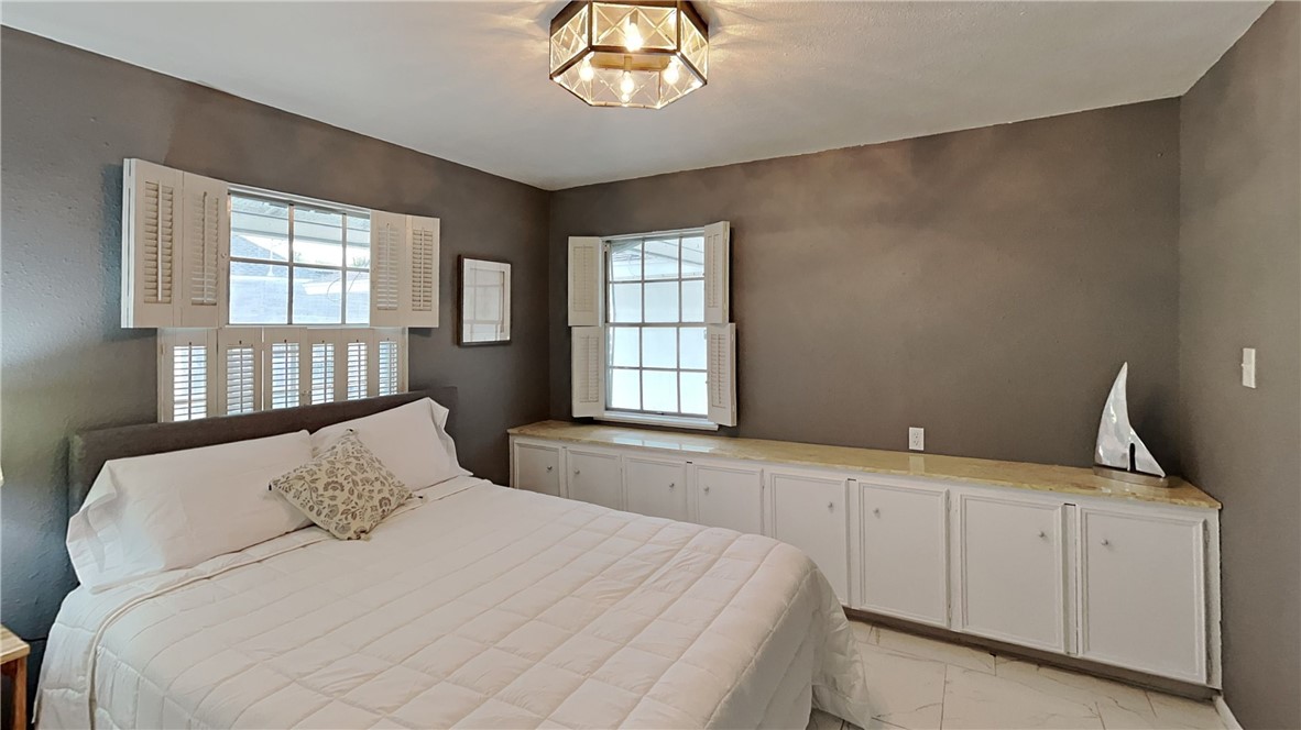 3554 Denver Avenue Corpus Christi, TX 78411 - Photo 15 of 21 a bedroom with a large bed and a chandelier
