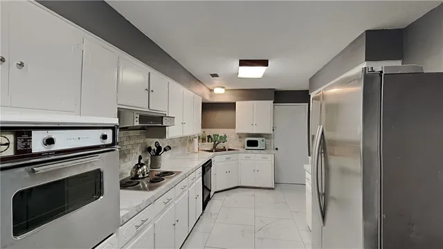 a kitchen with cabinets and stainless steel appliances