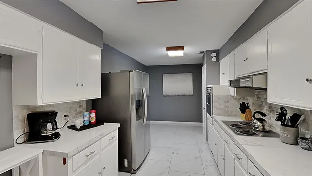 a kitchen with stainless steel appliances a sink stove refrigerator and cabinets