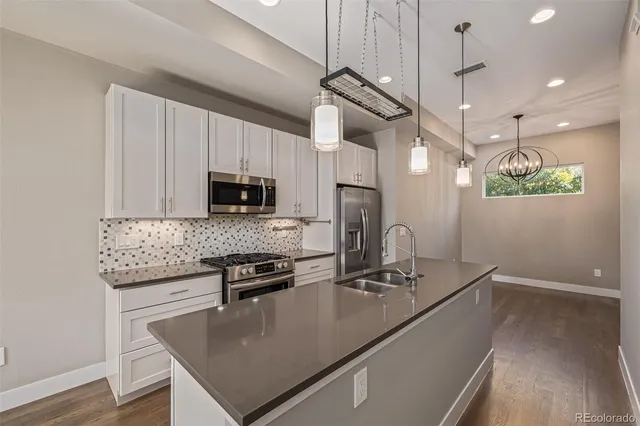 a kitchen with kitchen island granite countertop a sink stainless steel appliances and cabinets