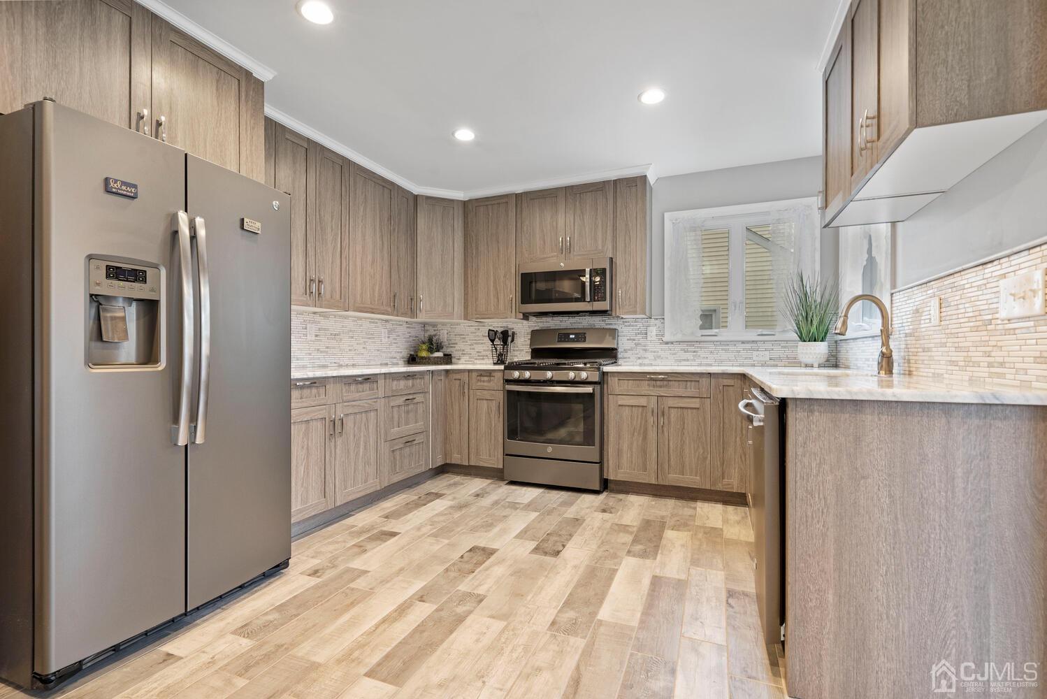 48 Lancaster Road Colonia, NJ 07067 - Photo 11 of 37 a kitchen with stainless steel appliances a refrigerator sink and cabinets