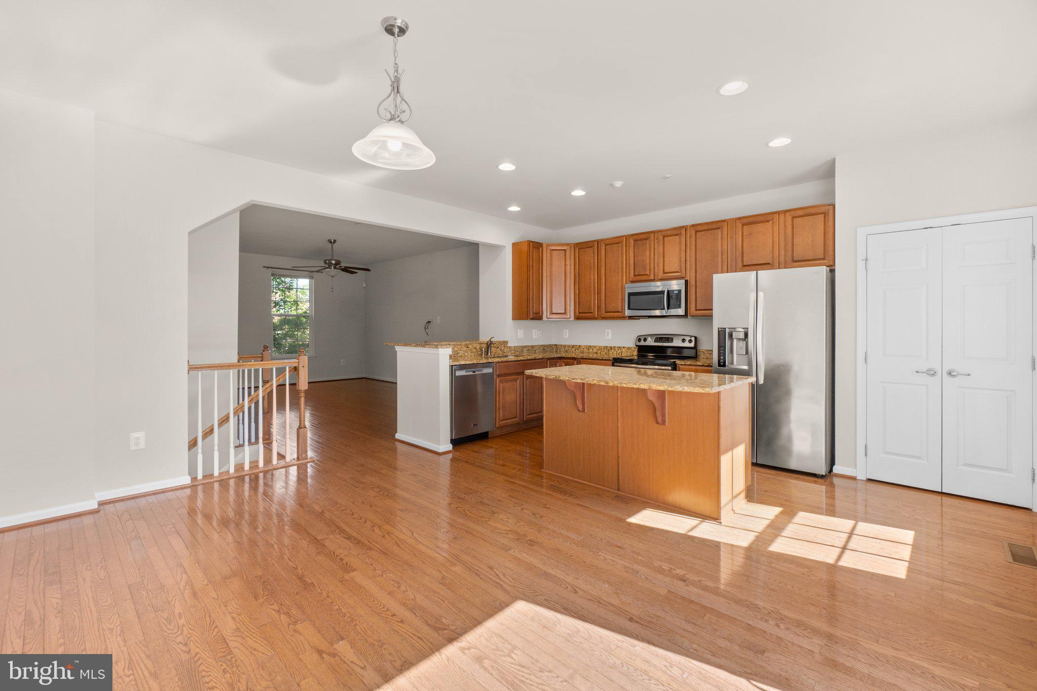 2061 Spring Run Circle Frederick, MD 21702 - Photo 11 of 42 a kitchen with stainless steel appliances granite countertop a refrigerator a stove top oven a sink dishwasher and white cabinets with wooden floor