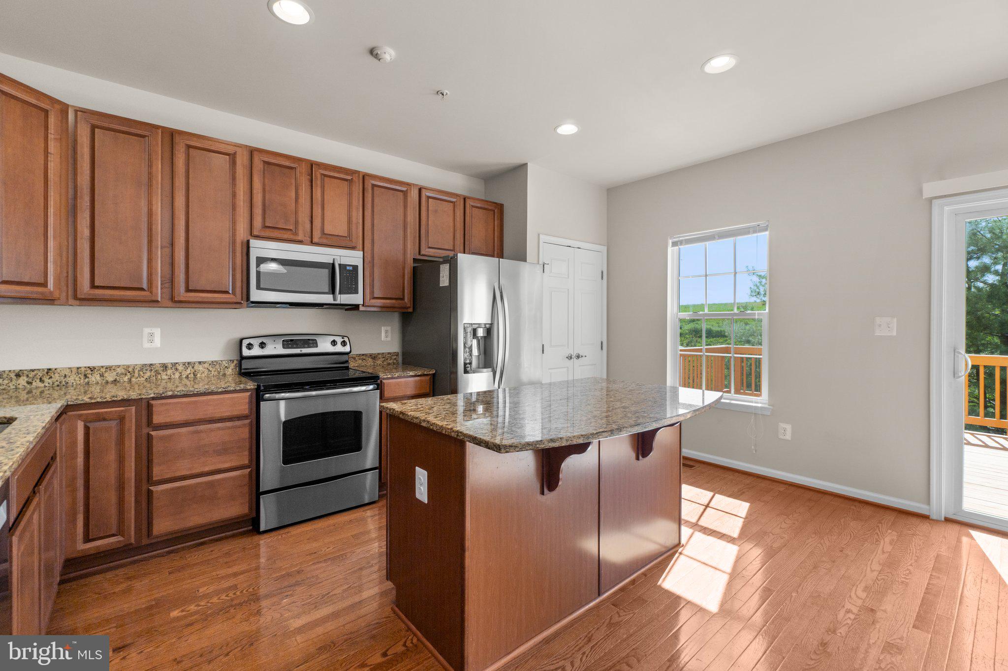 2061 Spring Run Circle Frederick, MD 21702 - Photo 13 of 42 a kitchen with stainless steel appliances granite countertop a stove a sink dishwasher a refrigerator and a microwave oven with wooden floor