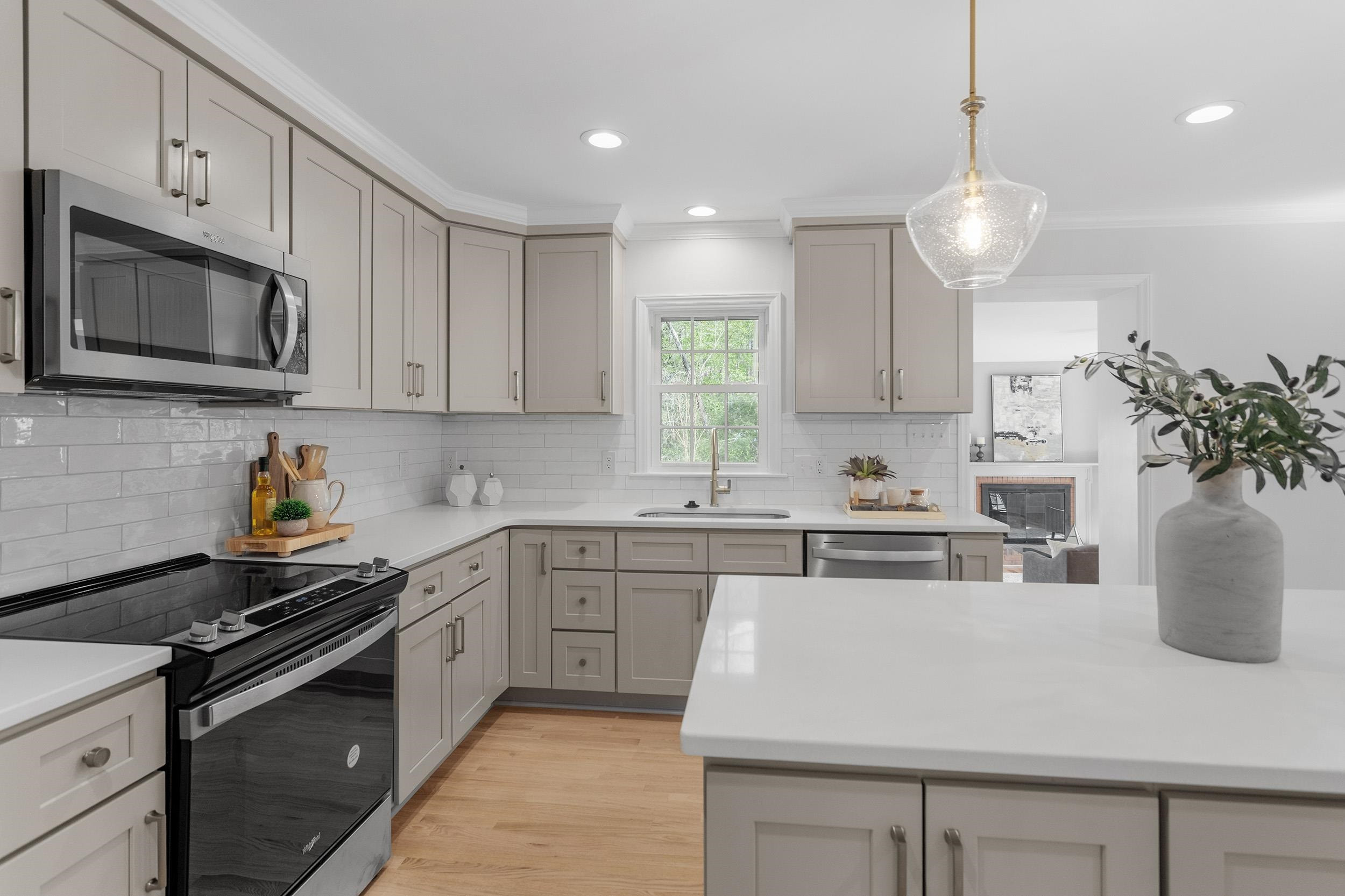 2906 Buckingham Road Durham, NC 27707 - Photo 17 of 34 a kitchen with kitchen island granite countertop a sink a stove oven a counter space and cabinets