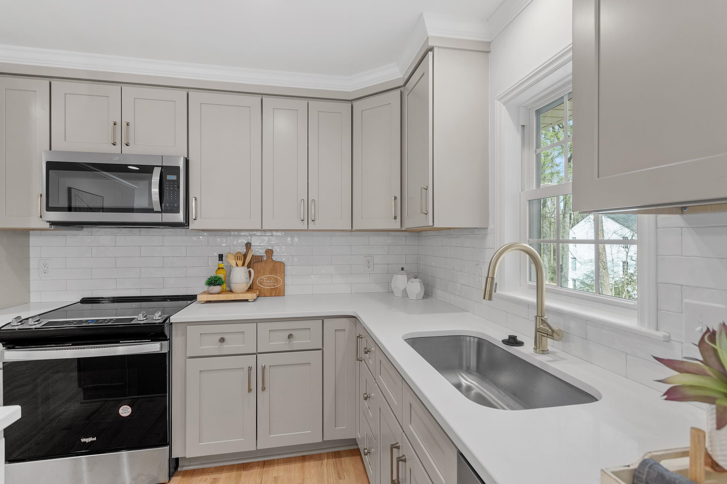 2906 Buckingham Road Durham, NC 27707 - Photo 18 of 34 a kitchen with white cabinets a sink and dishwasher