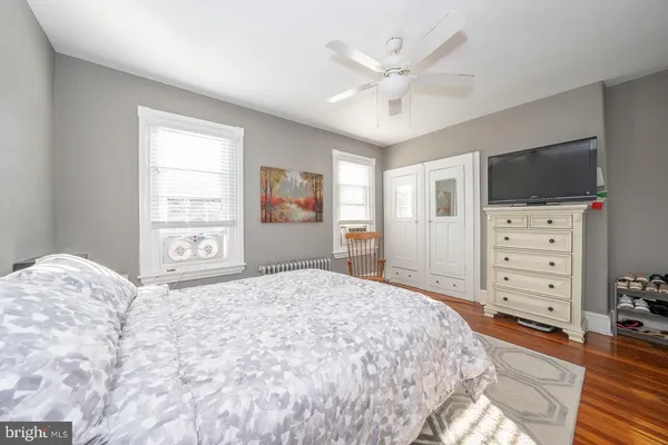 a bedroom with a large bed and a flat tv screen on dresser