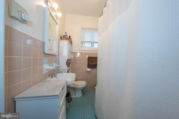 a bathroom with a sink toilet and mirror