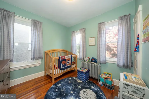 a bedroom with baby bed and a window