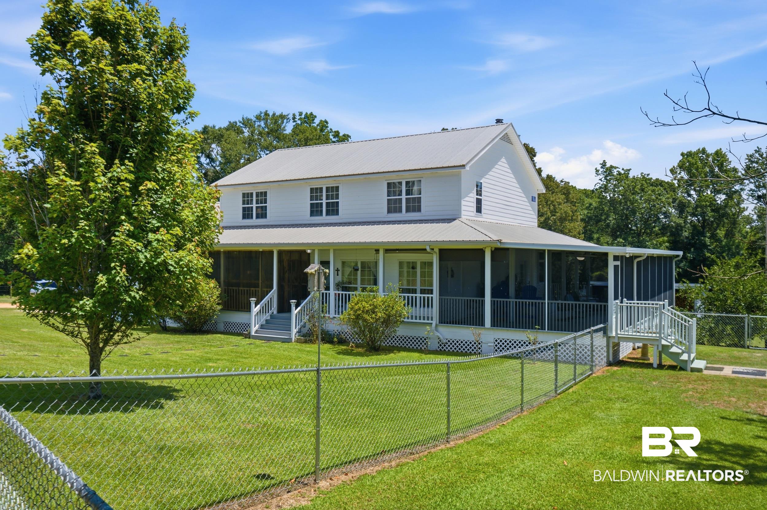 15855 Calvin Richerson Road Bay Minette, AL 36507 - Photo 5 of 83 Two-story white siding residence featuring a metal roof and a wrap-around screened porch