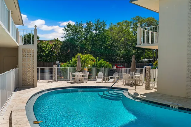 a view of a house with pool and chairs