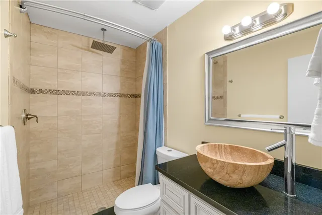 a bathroom with a granite countertop bathtub a sink and a mirror