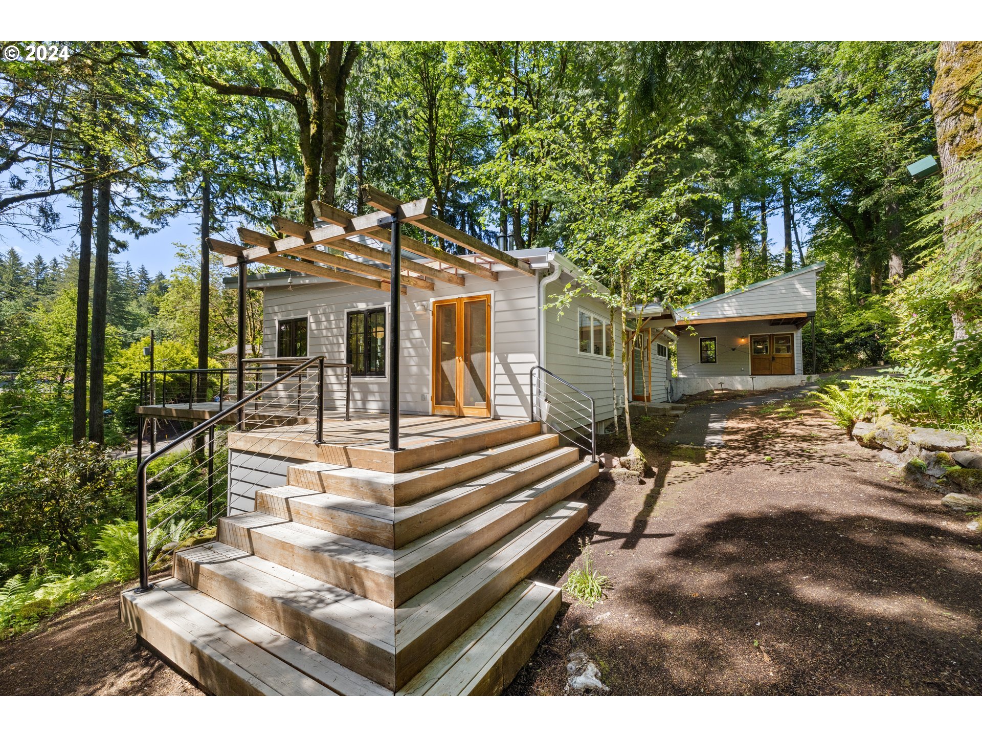 4710 Northwest Barnes Road Portland, OR 97210 - Photo 3 of 23 a view of a white house with a large tree and many windows