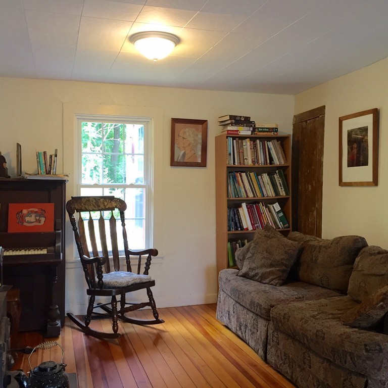 84-86 East Leverett Road Amherst, MA 01002 - Photo 7 of 29 a living room with furniture a bookshelf and a window