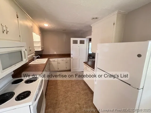 a kitchen with a refrigerator and a stove top oven