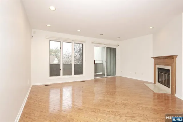 a view of an empty room with a fireplace and a window