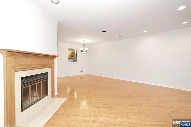 a view of empty room with kitchen and fireplace