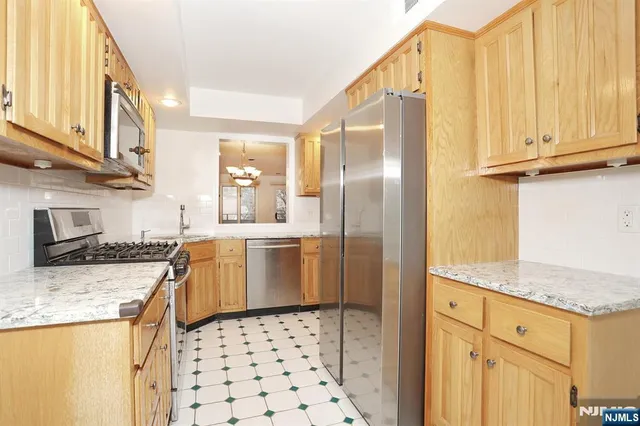 a kitchen with granite countertop a refrigerator and a sink