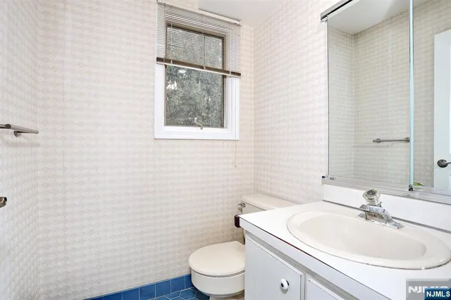 a bathroom with a toilet a sink and mirror