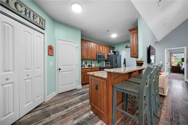 a kitchen with stainless steel appliances granite countertop a refrigerator and a stove top oven