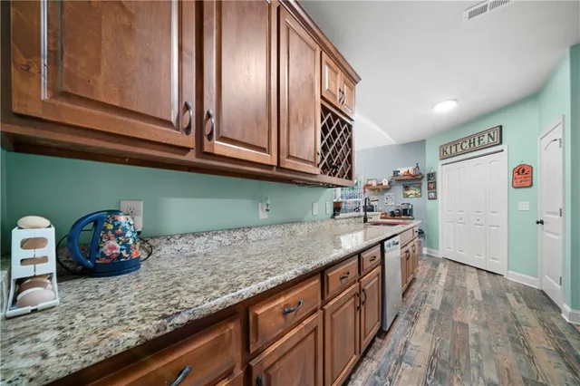 a kitchen with stainless steel appliances granite countertop a sink and dishwasher cabinets with wooden floor