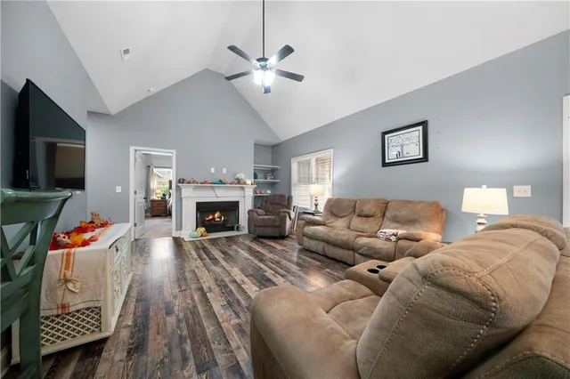a living room with furniture a flat screen tv and a fireplace