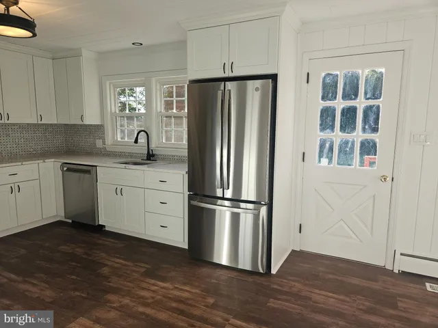 a kitchen with stainless steel appliances a refrigerator sink and cabinets