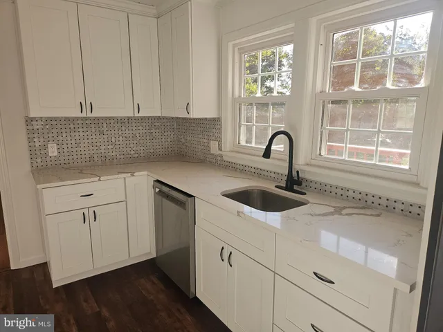 a kitchen with white cabinets appliances and a sink
