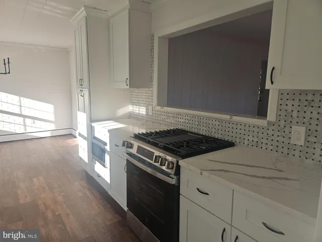 a stove top oven sitting inside of a kitchen