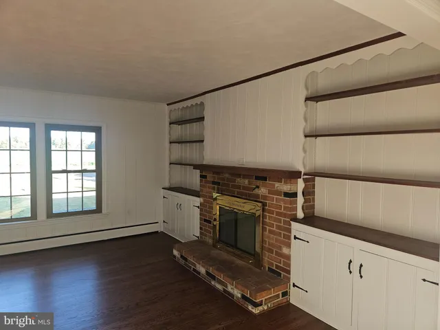 an empty room with wooden floor and cabinet