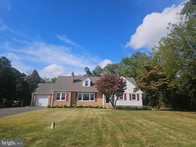 a view of a big house with a big yard and large tree