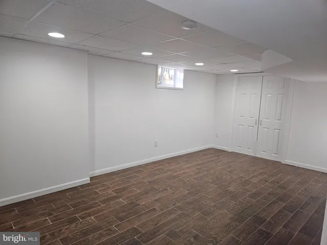 an empty room with a wooden floor and a window