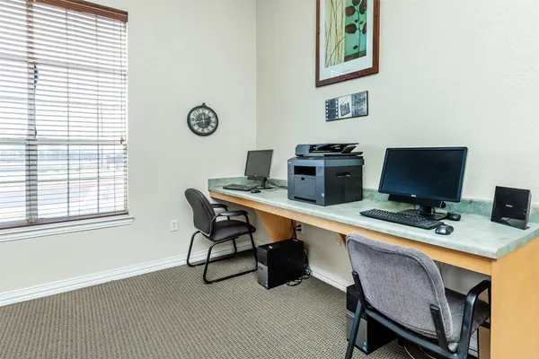 a view of a workspace with furniture and a window