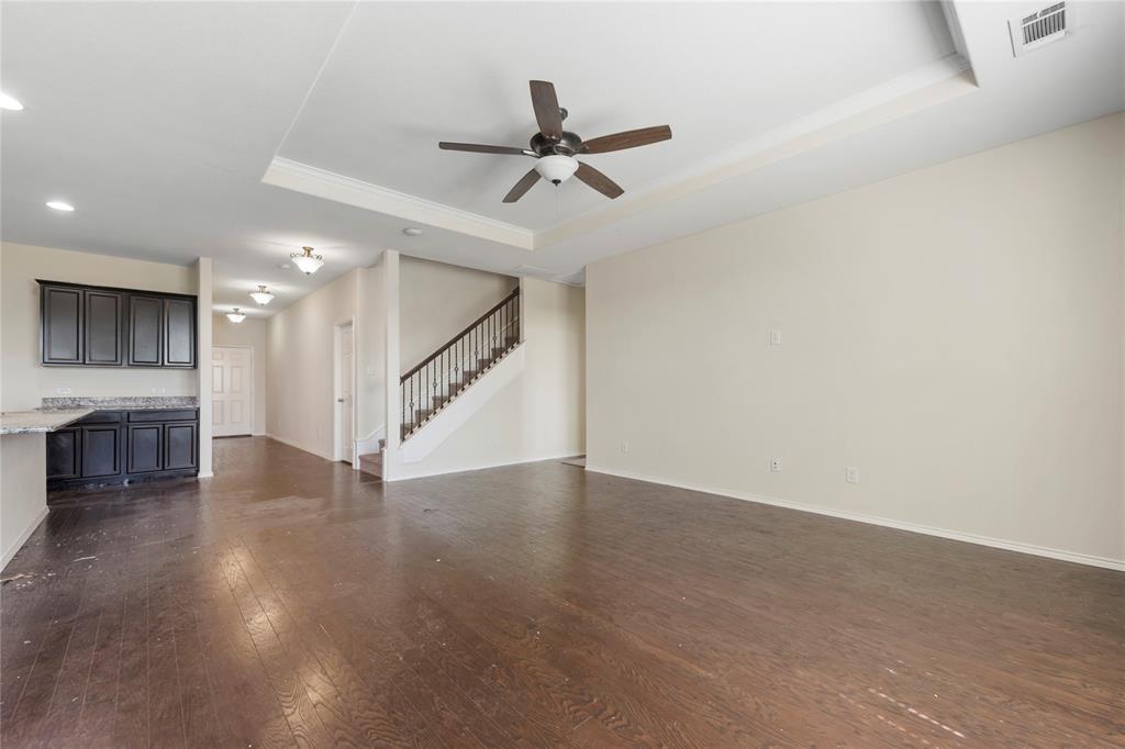 2239 Heaton Street Forney, TX 75126 - Photo 11 of 25 an empty room with wooden floor ceiling fan and windows