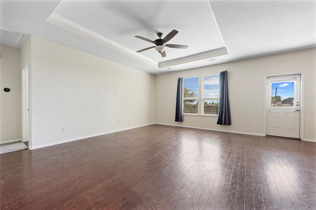 2239 Heaton Street Forney, TX 75126 - Photo 12 of 25 an empty room with wooden floor chandelier fan and windows