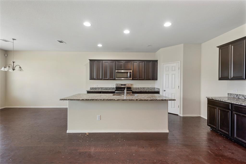 2239 Heaton Street Forney, TX 75126 - Photo 7 of 25 a kitchen with stainless steel appliances granite countertop a sink a stove top oven a counter space and cabinets