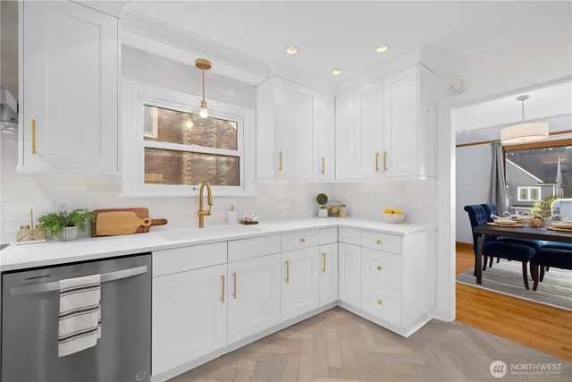 a kitchen with white cabinets and sink