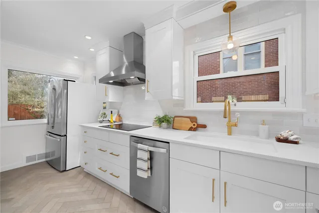 a kitchen with stainless steel appliances granite countertop a sink and a refrigerator