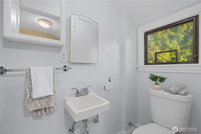 a bathroom with a sink a toilet and a mirror