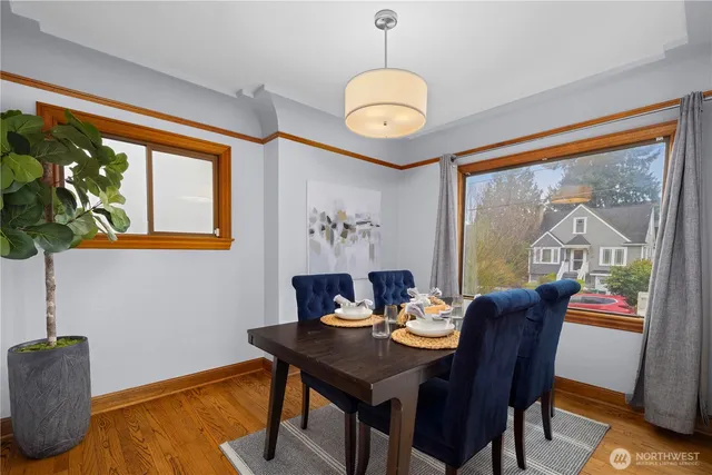 a view of a dining room with furniture a chandelier and wooden floor
