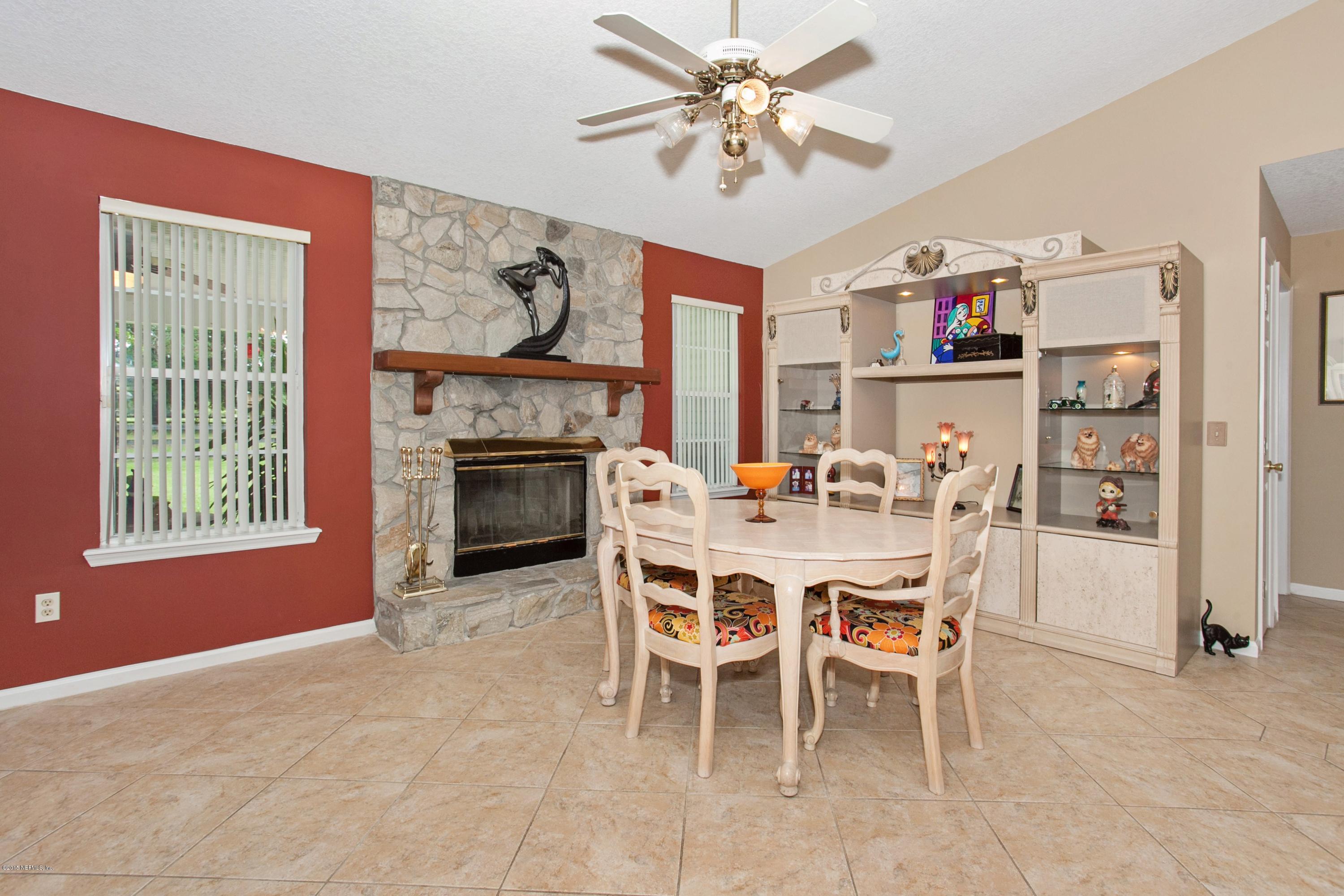 4735 Wolfe Road St. Augustine, FL 32092 - Photo 11 of 39 a dining room with furniture a fireplace and a chandelier