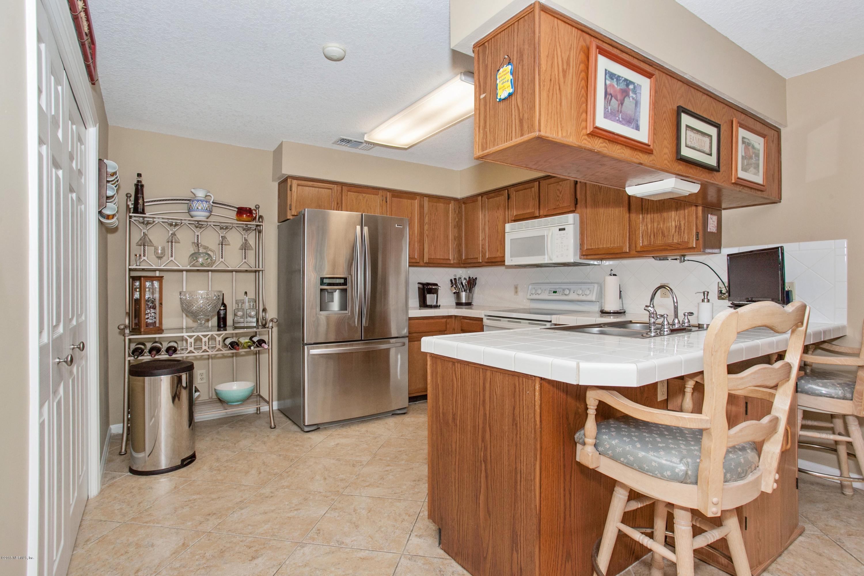 4735 Wolfe Road St. Augustine, FL 32092 - Photo 12 of 39 a kitchen with stainless steel appliances granite countertop a refrigerator a sink a stove and island