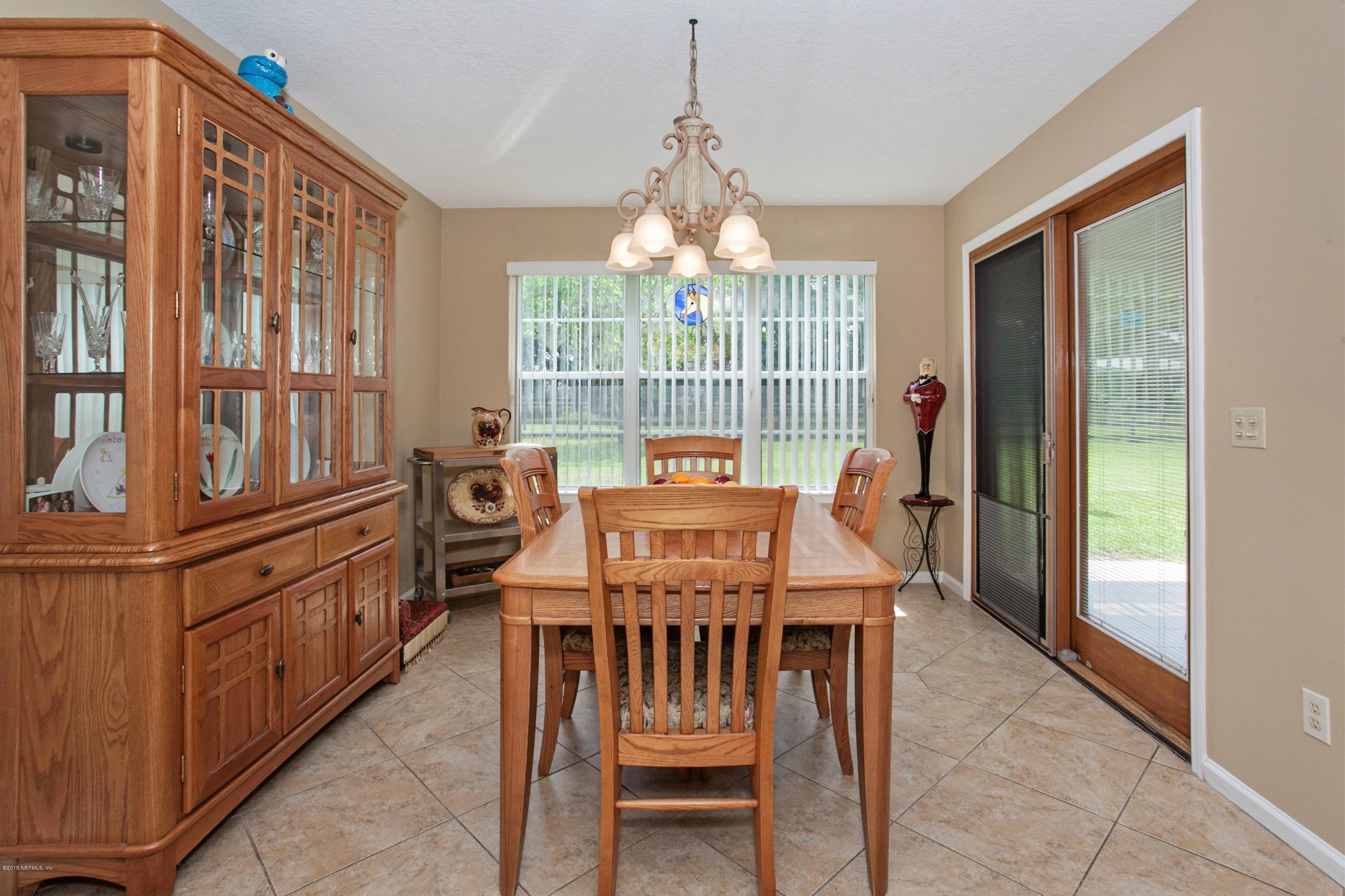 4735 Wolfe Road St. Augustine, FL 32092 - Photo 14 of 39 a dining room with furniture a chandelier and fireplace