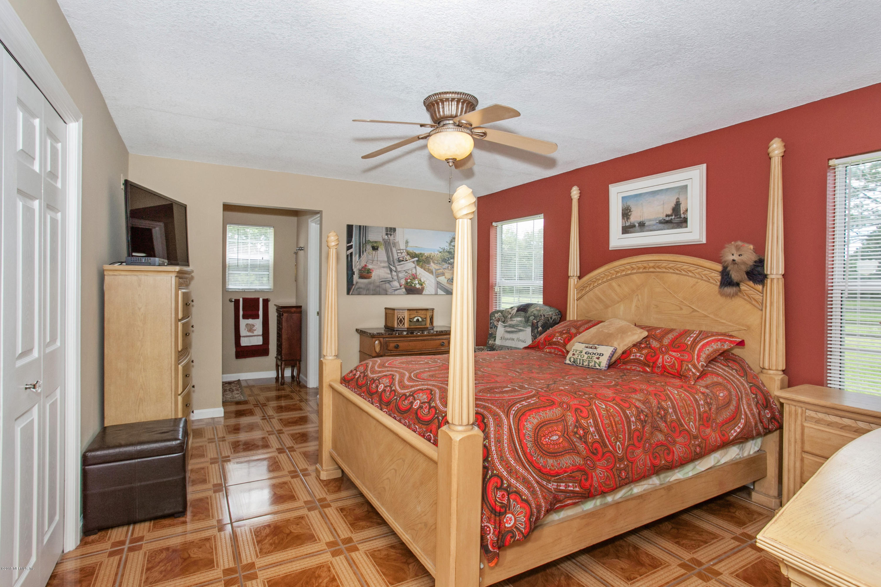 4735 Wolfe Road St. Augustine, FL 32092 - Photo 18 of 39 a bedroom with bed and a chandelier