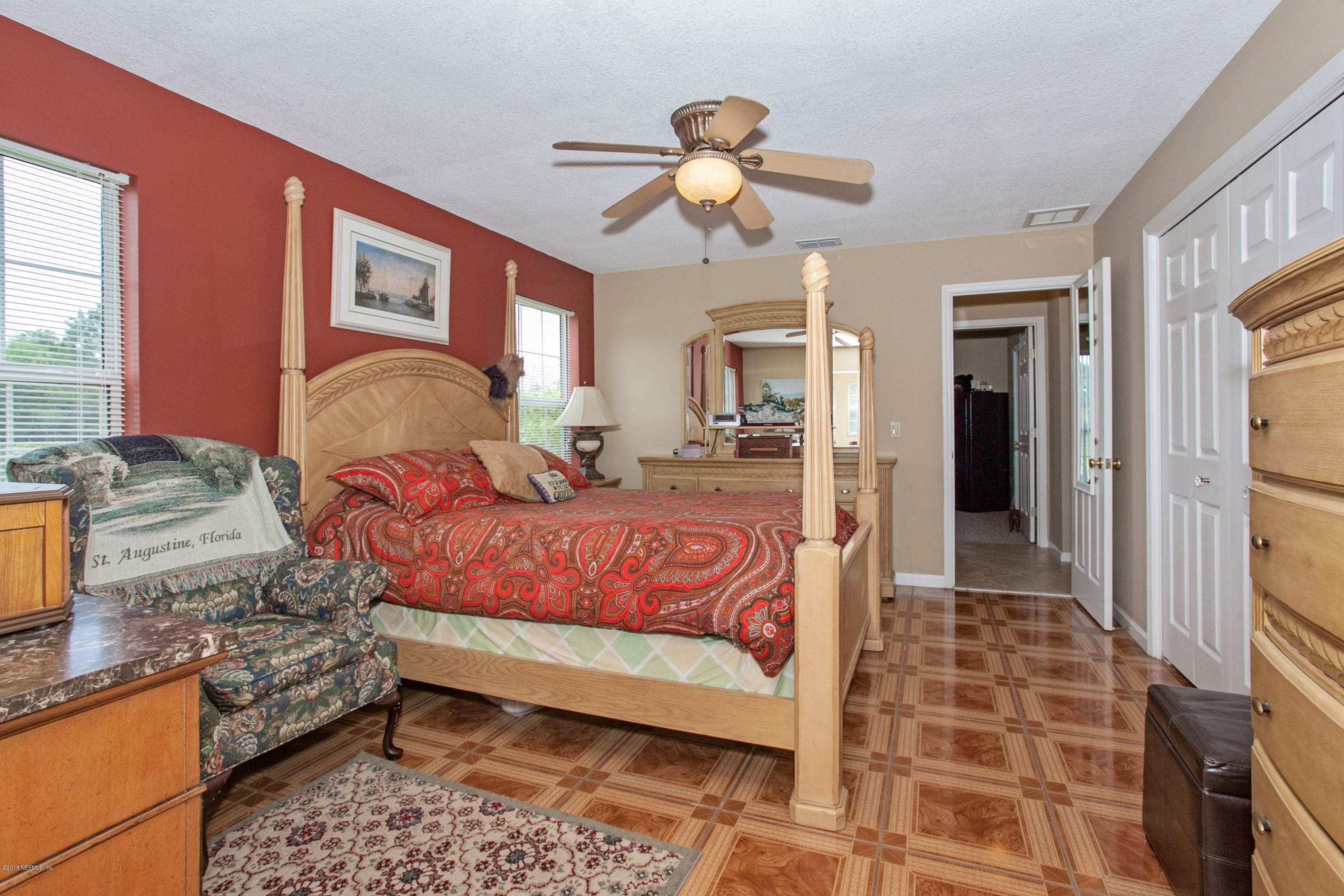 4735 Wolfe Road St. Augustine, FL 32092 - Photo 19 of 39 a bedroom with a large bed and a chandelier