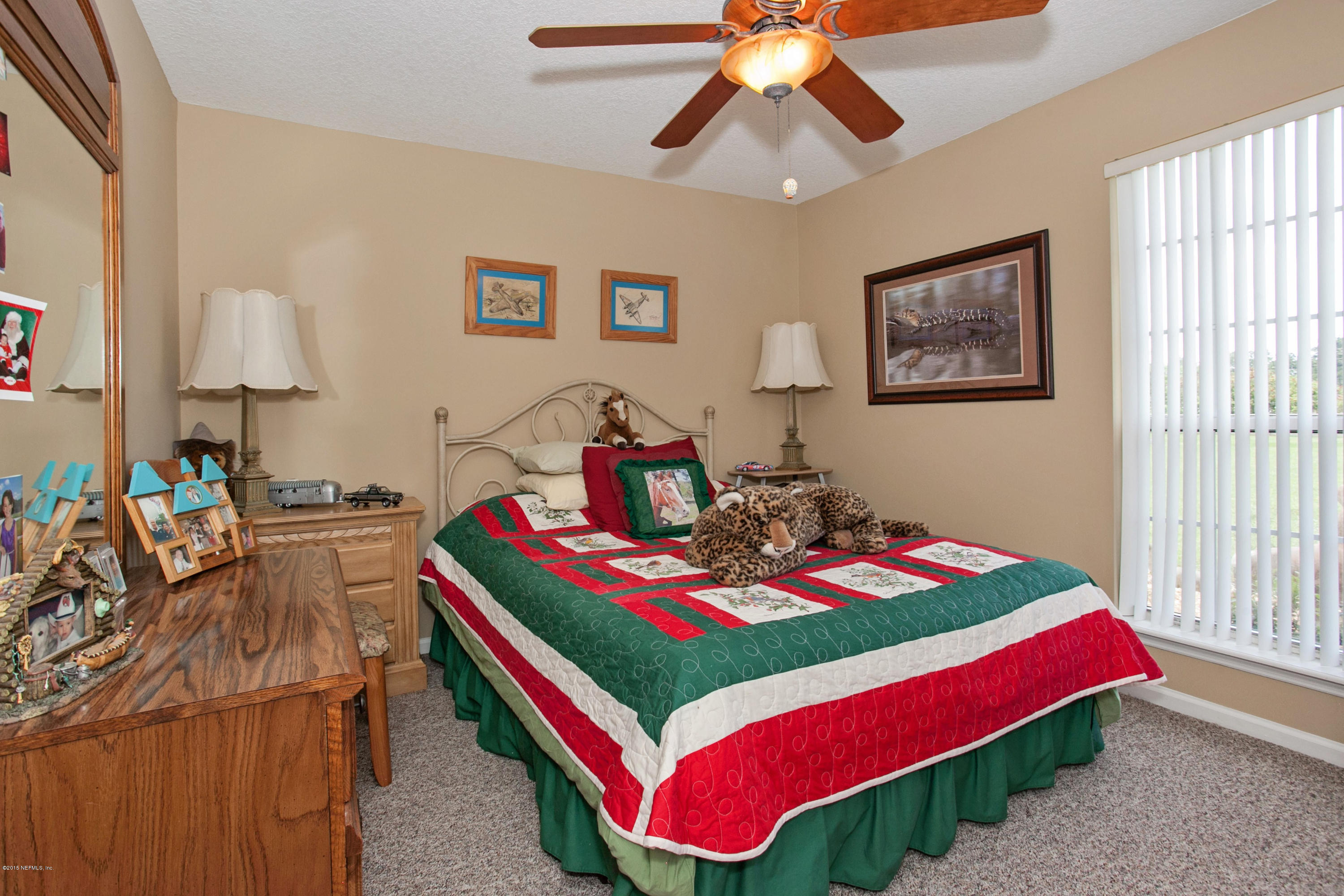 4735 Wolfe Road St. Augustine, FL 32092 - Photo 21 of 39 a bedroom with bed and a chandelier