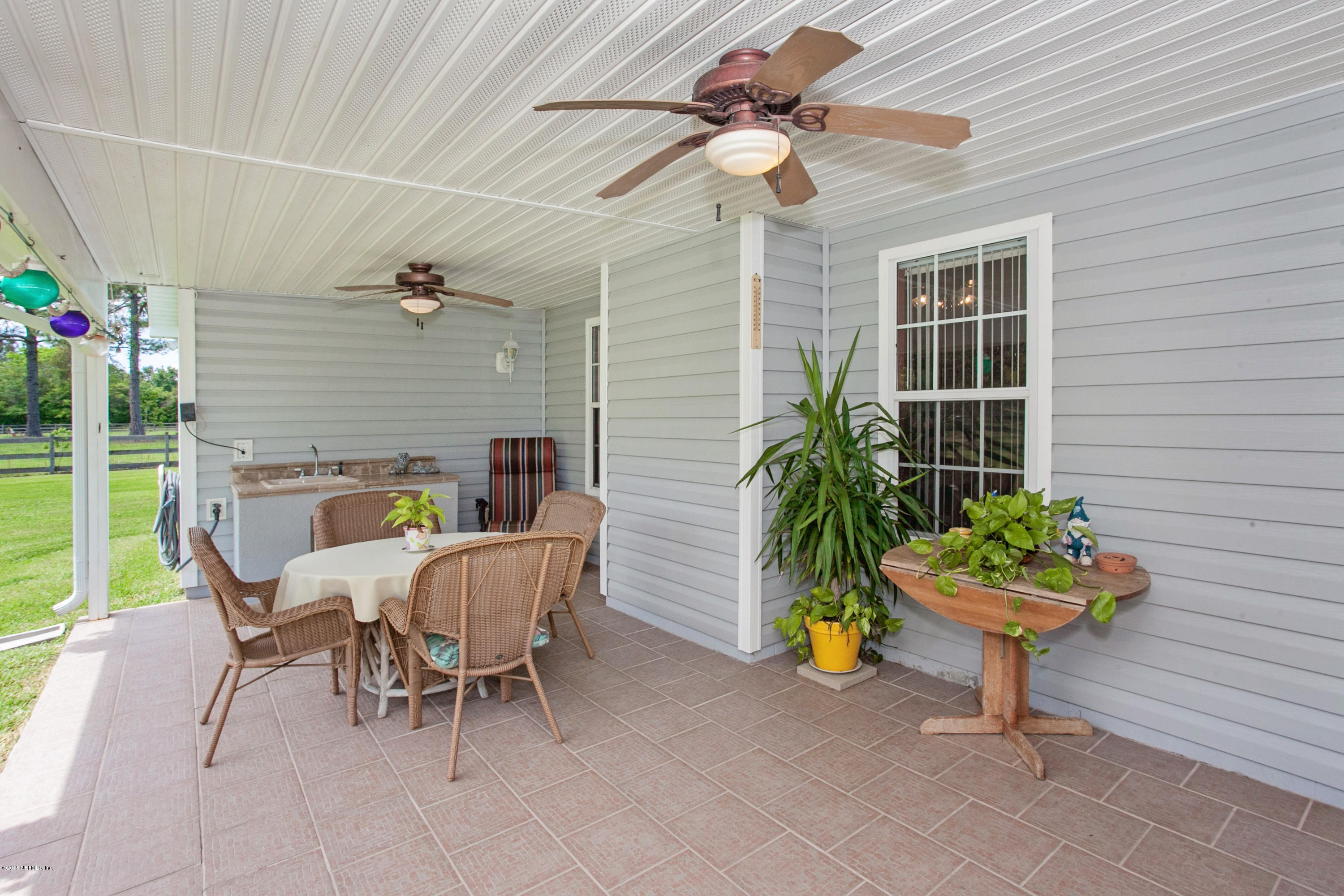 4735 Wolfe Road St. Augustine, FL 32092 - Photo 24 of 39 a view of a patio with a chairs and potted plants
